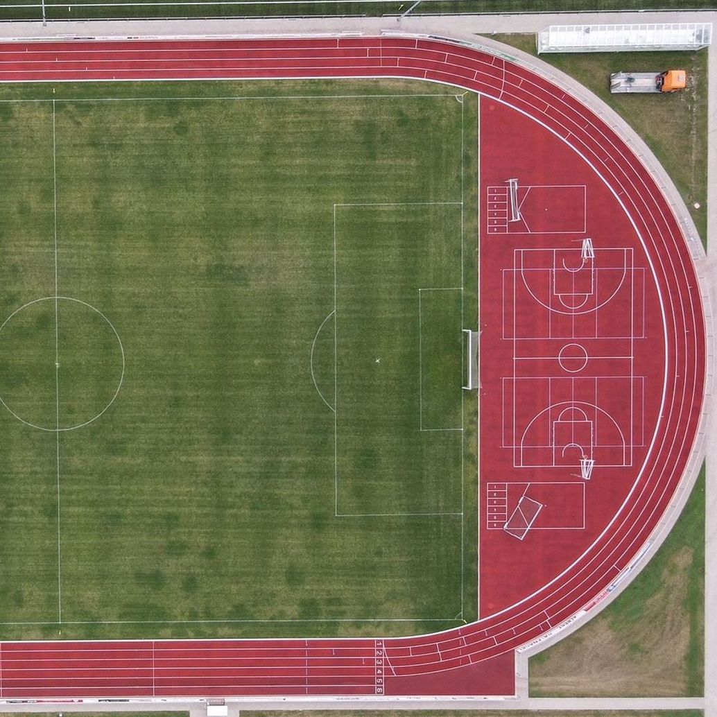 Sportplatz aus der Vogelperspektive mit umlaufender gereinigter Tartanbahn