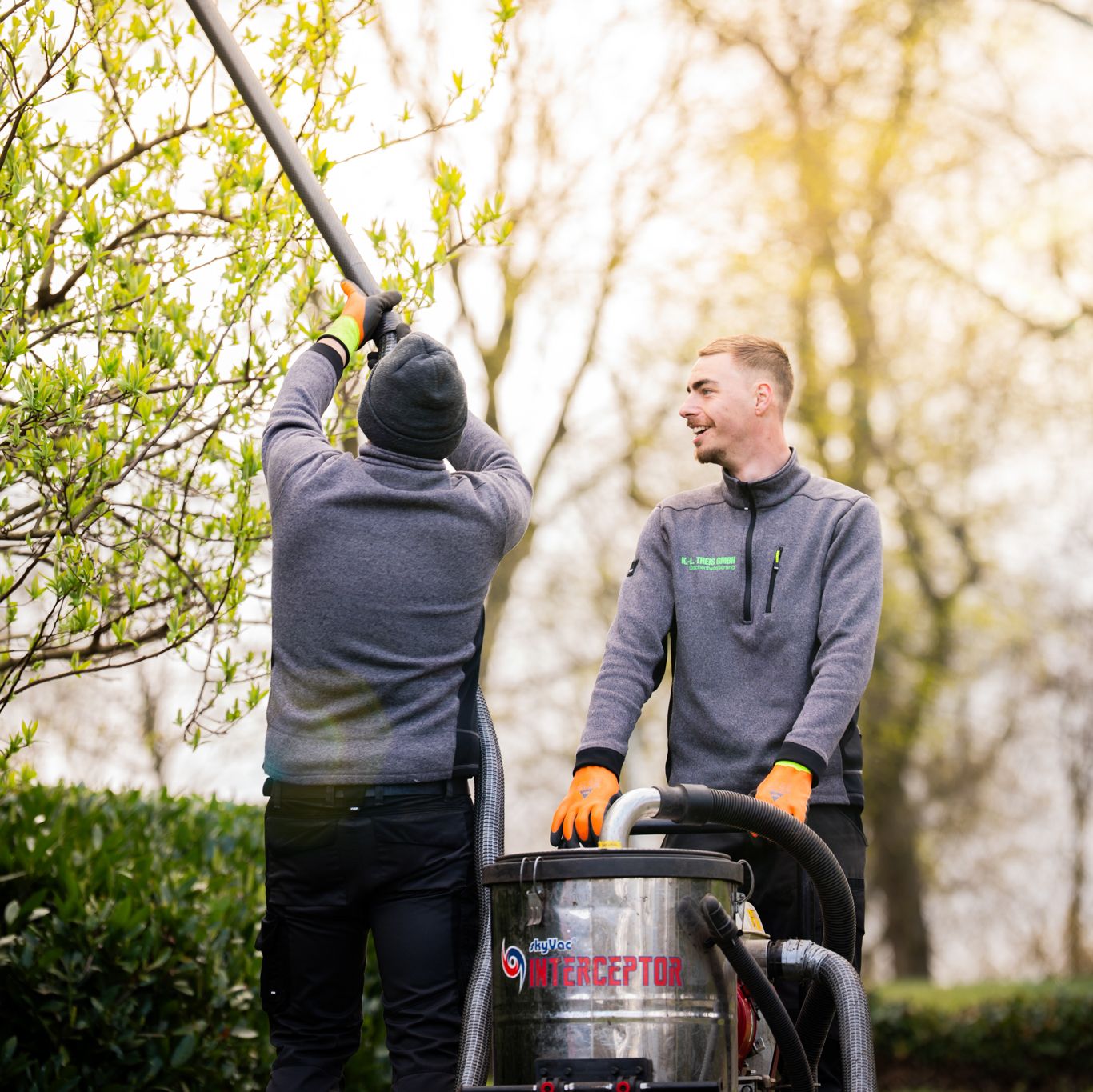 Zwie Mitarbeiter stehen an einem Gebläse und schauen nach oben