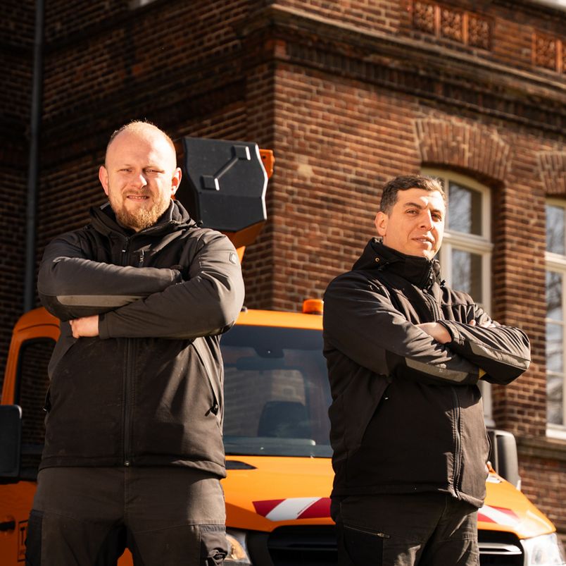 Mitarbeiter stehen mit verschränkten Armen vor einem Theis Fahrzeug