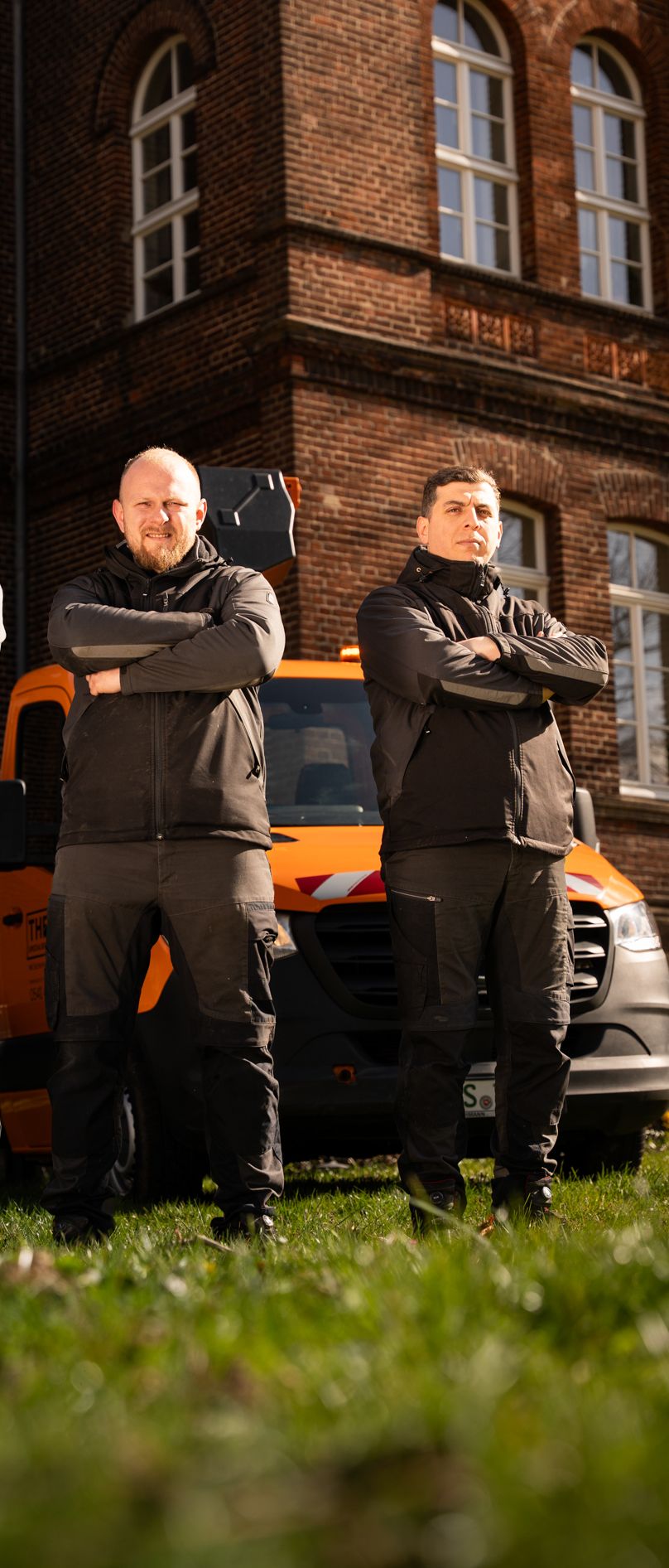 Drei Mitarbeiter stehen mit verschränkten Armen vor einem Auto der Theis Spezialreinigung 