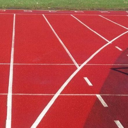 Gereinigte Tartanbahn, deren Rotton in der Sonne leuchtet