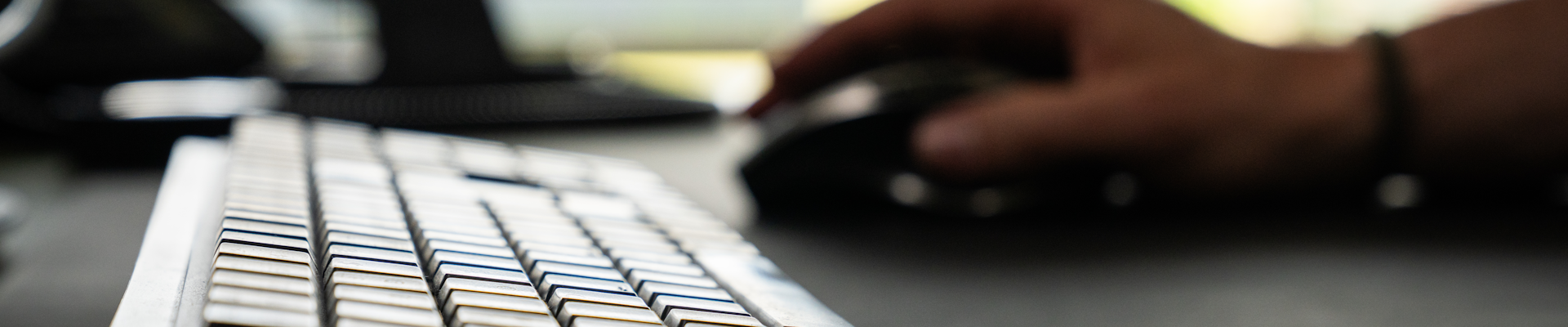 Bild zeigt eine Tatstatur und im Hintergund eine Computermaus